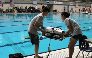 Students by the pool with device at 12th Annual ROV Competition